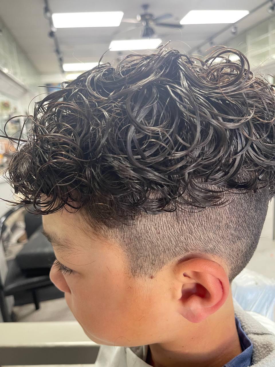 Kids' curls up top with a high skin fade